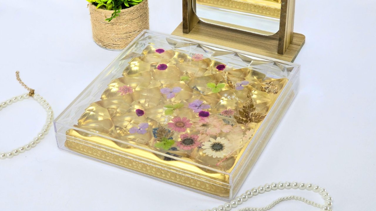 Upcycled Ferrero Rocher jewelry box, a clear acrylic box with pressed flowers on the lid and gold compartments for jewelry