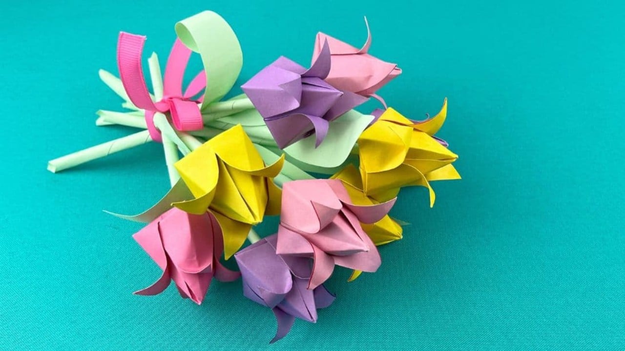 How to make paper tulips, folded origami tulips in pink, yellow, purple and green on a bright teal surface
