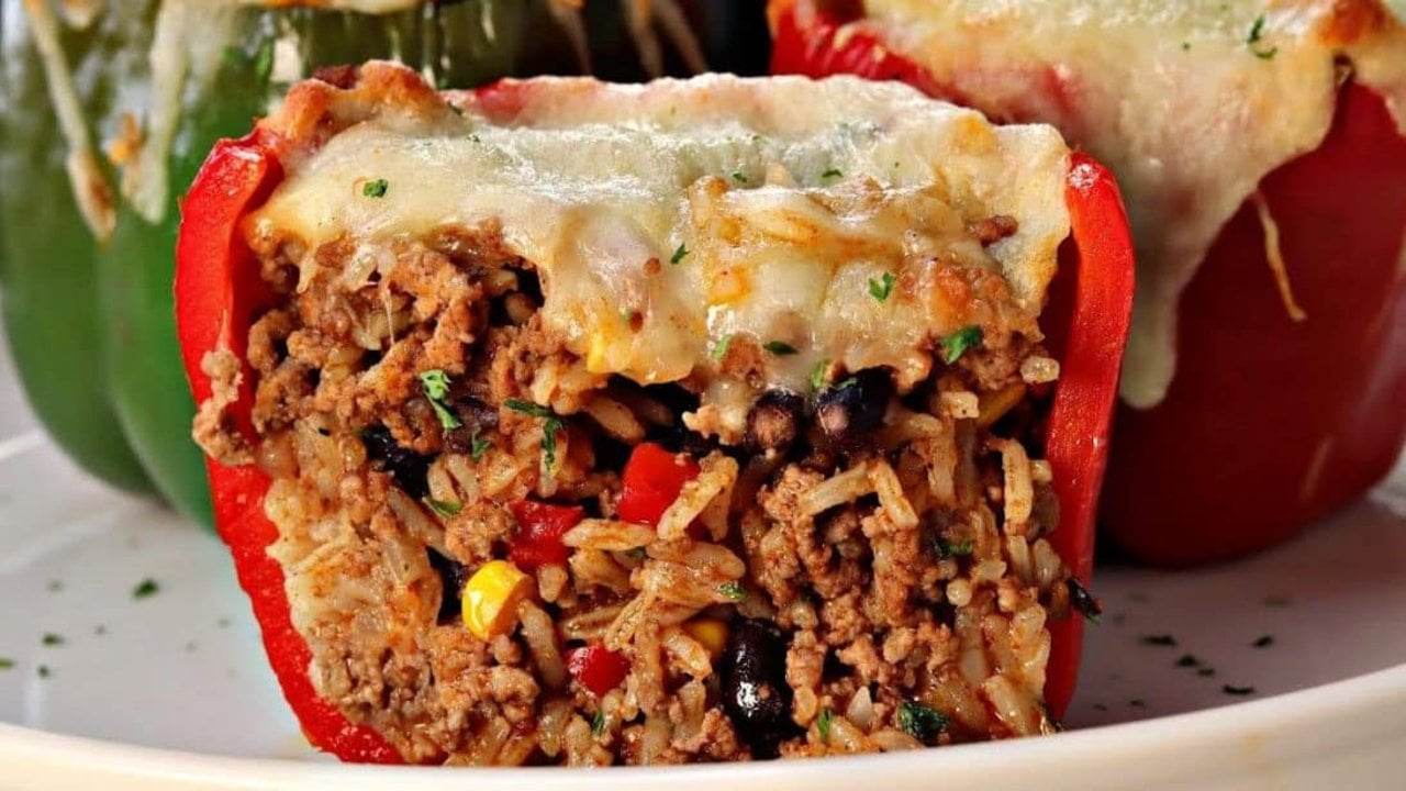 Mexican stuffed bell peppers filled with seasoned ground beef, rice, beans and melted mozzarella ready to serve at home