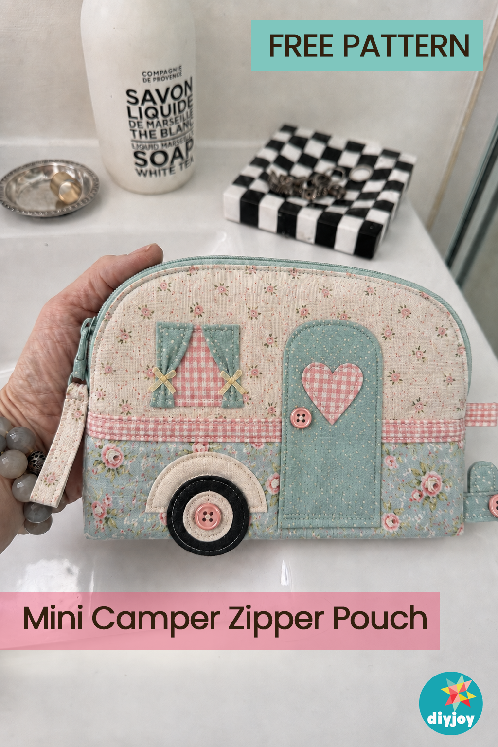 Free Camper Zipper Pouch Pattern Pink and mint camper shaped zipper pouch with an applique door and heart, gingham curtains and a button wheel