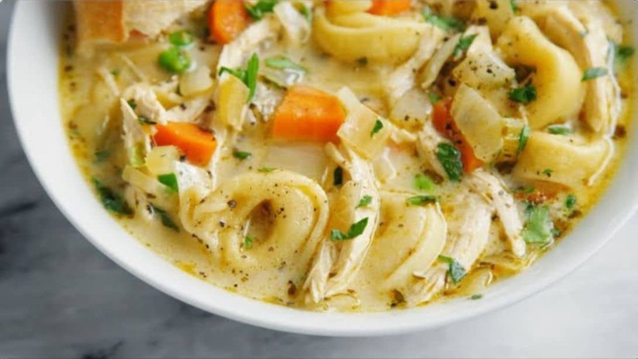 Creamy chicken tortellini soup with carrots, peas and cheese tortellini in a rich broth with parsley