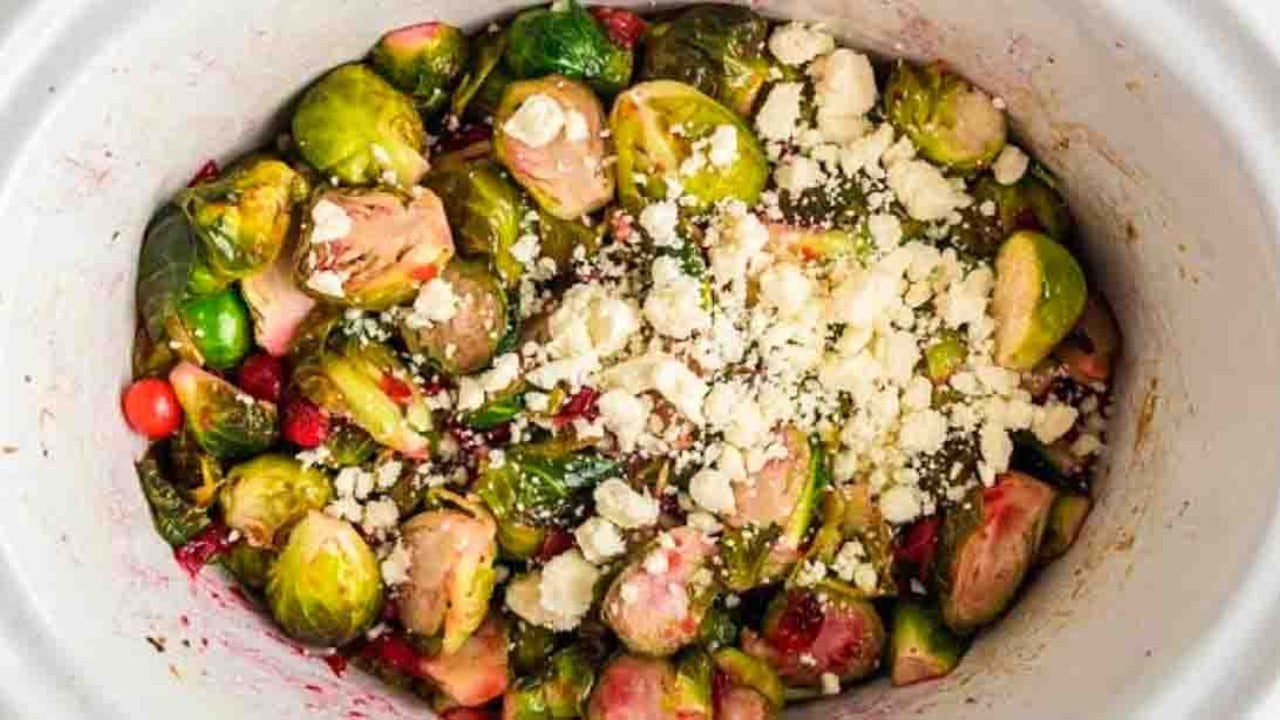 Crockpot brussels sprouts with fresh cranberries and crumbled feta cooked in a maple syrup and honey glaze