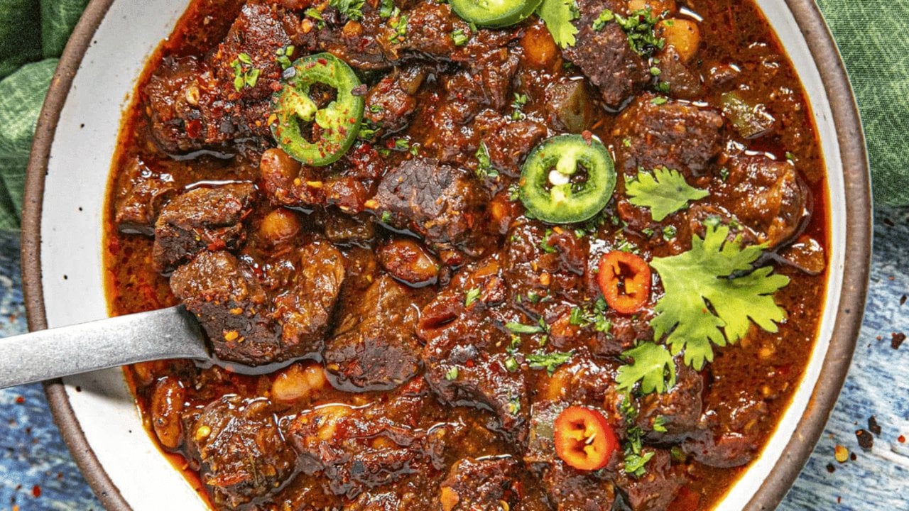 Easy Chili Con Carne, Dutch Oven Style Chili con carne simmered in a dutch oven with cubed chuck roast and a red sauce made from dried chiles