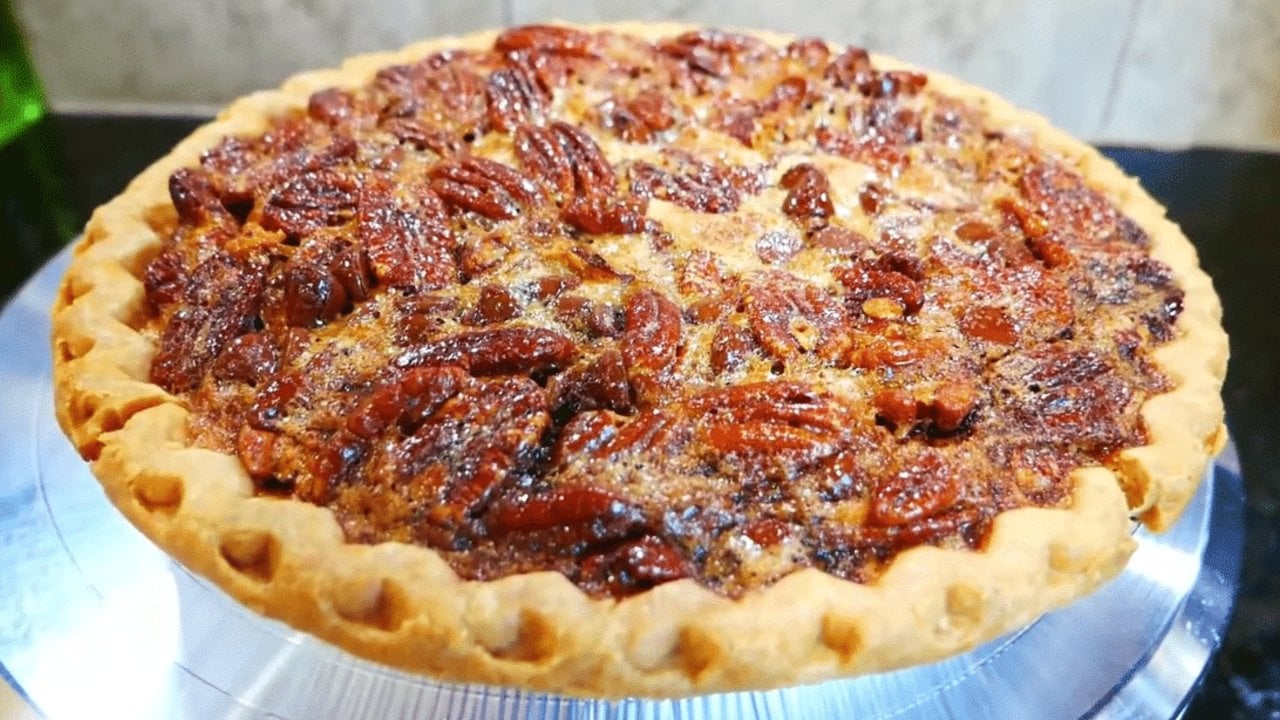 Easy chocolate chip pecan pie with whole pecans and melted chocolate chips in a deep dish golden crust