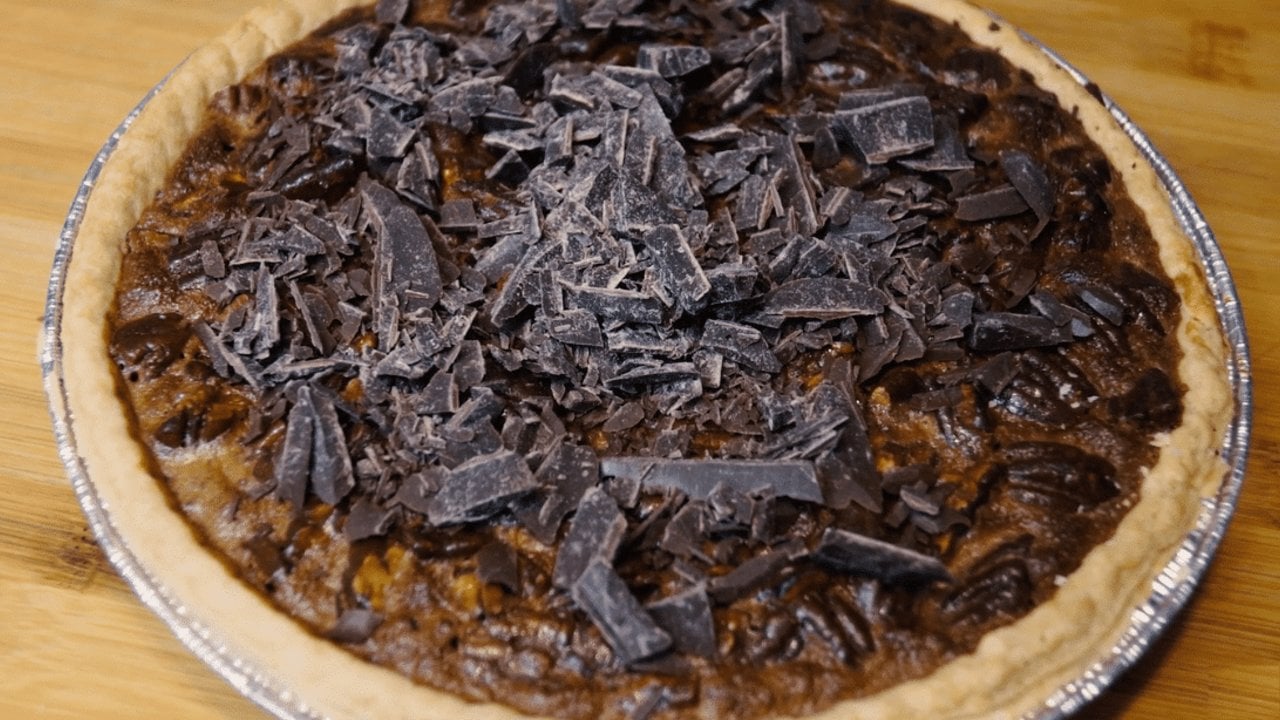 Easy chocolate pecan pie from scratch with toasted pecans and shaved chocolate over a rich fudgy filling