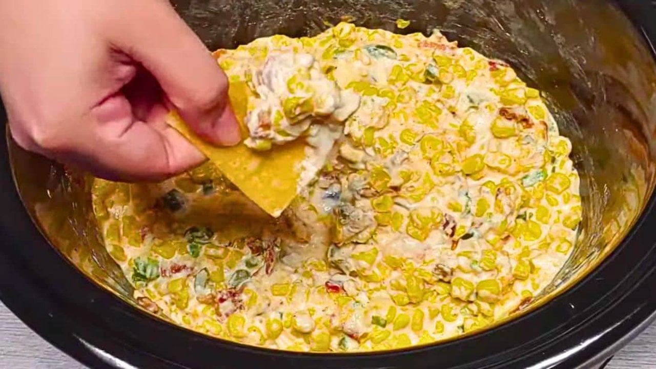 Crockpot cheesy jalapeno corn dip with sweet corn, crisp bacon and green onions through hot melted cheese