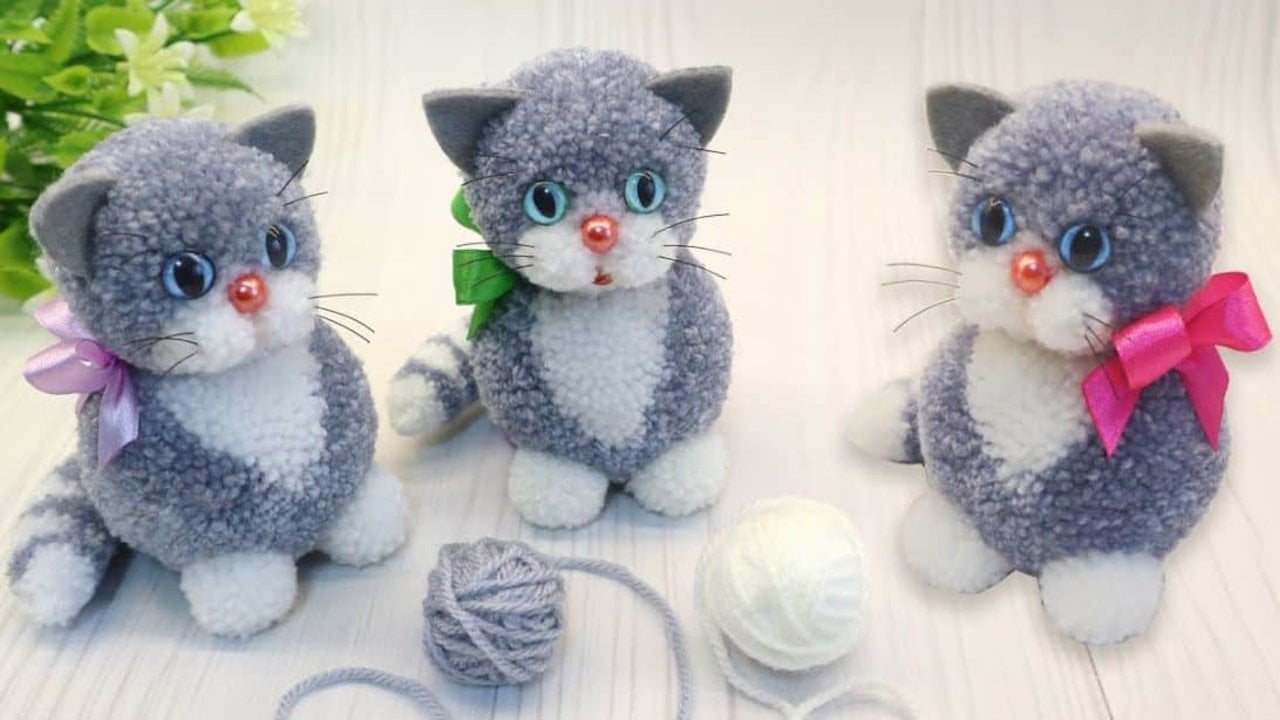 Yarn Kittens Made Without Sewing or Crochet Easy DIY yarn kitten, three fluffy grey and white yarn kittens with blue eyes and ribbon bows beside balls of yarn