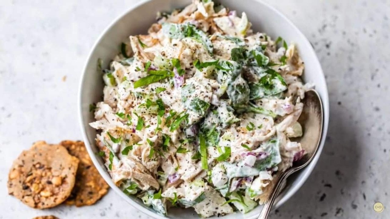 Easy healthy chicken salad with celery, red onion and baby spinach in Greek yogurt and mayonnaise ready to serve at home