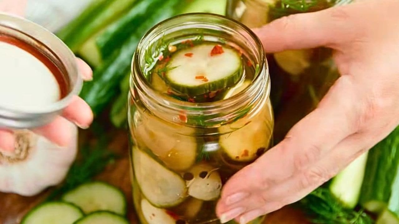 Easy overnight refrigerator pickles in a jar with cucumber spears, garlic cloves, peppercorns and fresh dill
