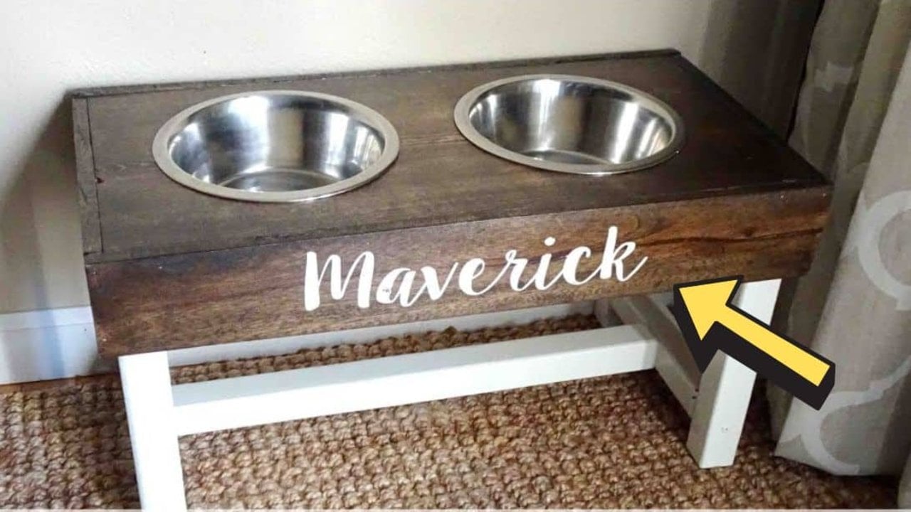 Easy to build DIY dog bowl stand, a dark stained wood stand on white legs holding two steel bowls, a name on the front