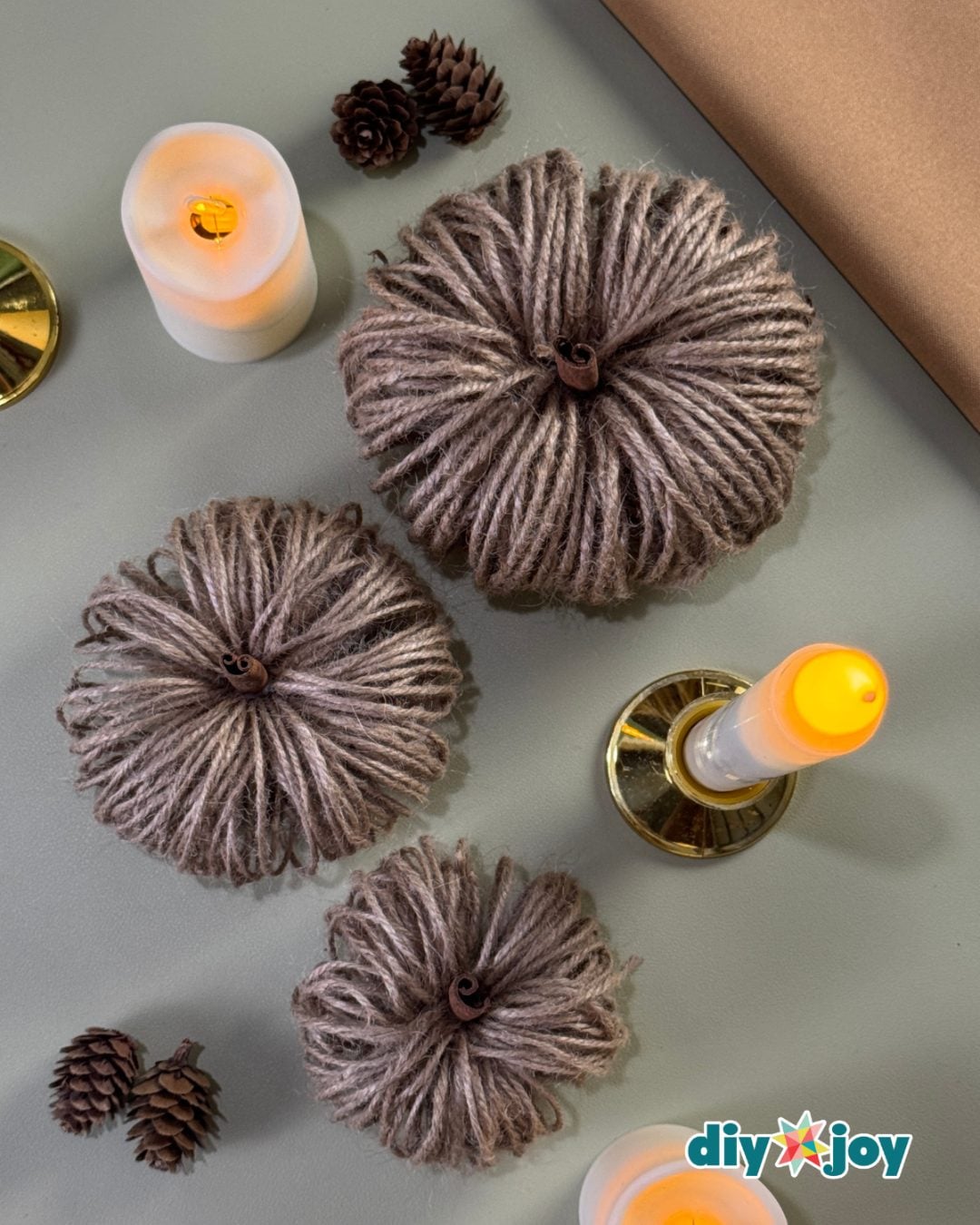 Twine pumpkin fall craft displayed with candles as rustic Thanksgiving table decor