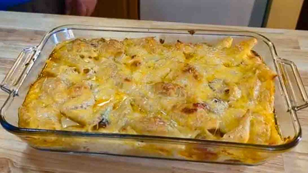 Giant Mac and Cheese Jumbo Shells Jumbo pasta shells under a deeply browned cheese top in a glass 9x13 baking dish on a wooden kitchen counter