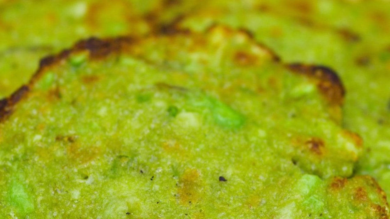 Crispy Baked Avocado Chips Keto Snack Extreme close up of bright green baked avocado and parmesan mixture with browned scorched edges filling the frame