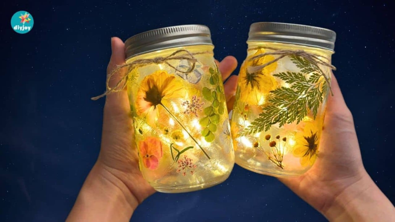Mason Jar Fairy Lights With Pressed Flowers Mason jar decorated with pressed flowers and lit from the inside by a string of warm white fairy lights