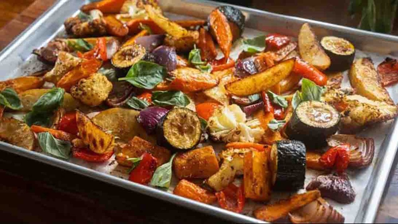 One-Pan Roasted Vegetables Recipe One pan roasted vegetables with peppers, carrots, cauliflower and sweet potato browned on a sheet pan