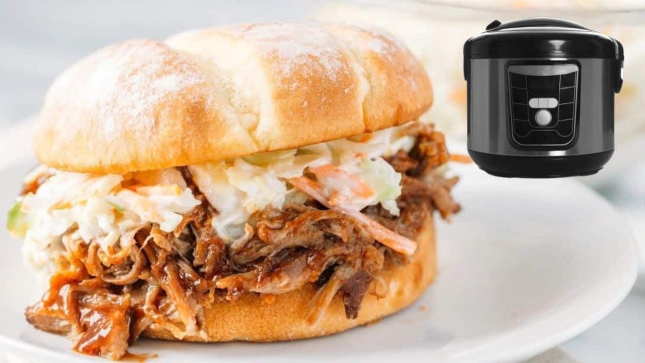 Slow cooker BBQ pulled pork shredded in a crockpot with barbecue sauce and chopped onion ready for the grill