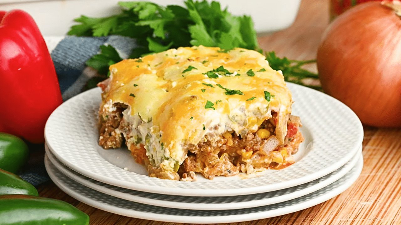 John Wayne casserole with a biscuit base, seasoned ground beef, peppers and melted cheddar in a baking dish