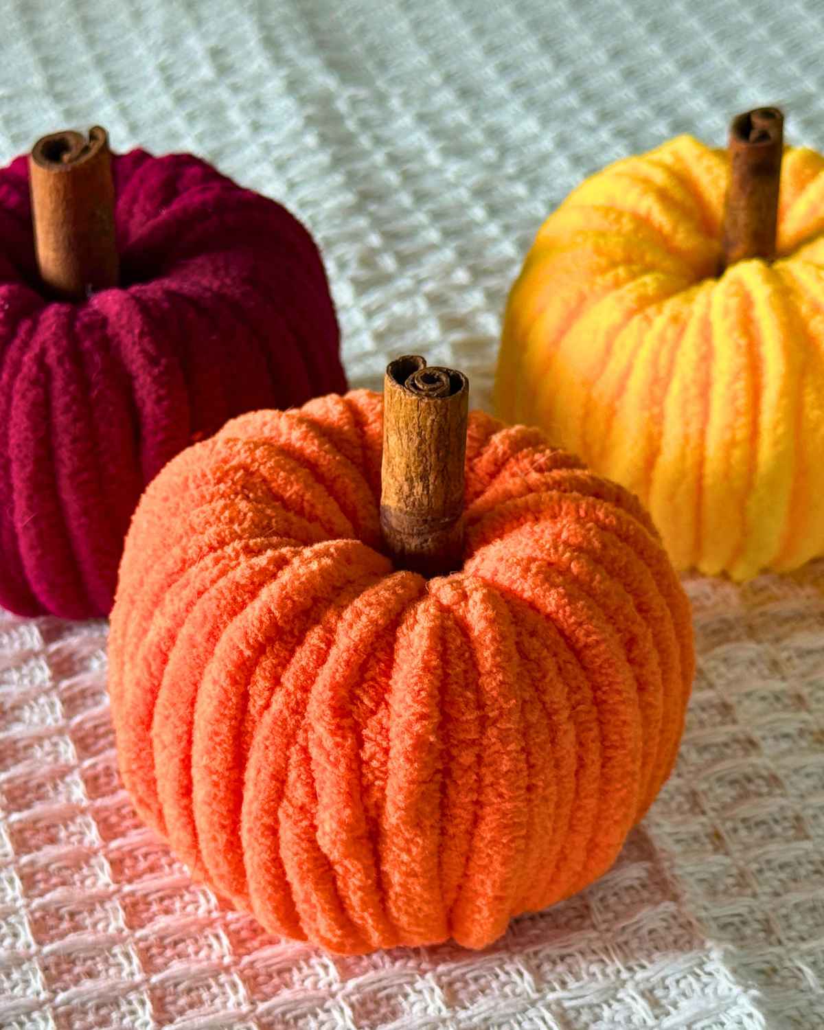 Best DIY Crafts - a finished chenille yarn pumpkin with a cinnamon stick stem