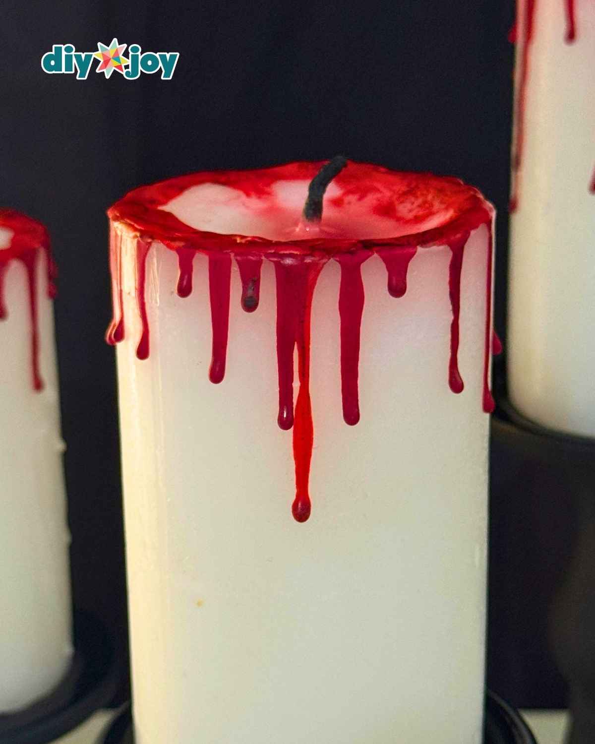 Finished DIY bloody candle glowing as spooky Halloween party decor with red wax drips