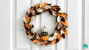 DIY fall wreath - finished felt leaf wreath with stacked fabric pumpkins on a white door