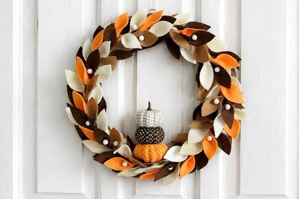 DIY fall wreath - finished felt leaf wreath with stacked fabric pumpkins on a white door