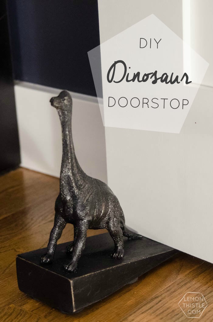 Grey painted dinosaur figure used as a doorstop on a wood floor