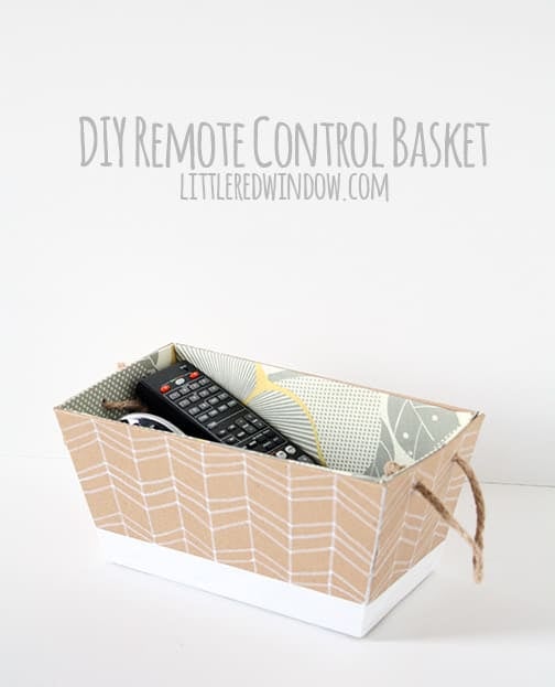 Fabric lined woven basket holding TV remotes on a cream sofa