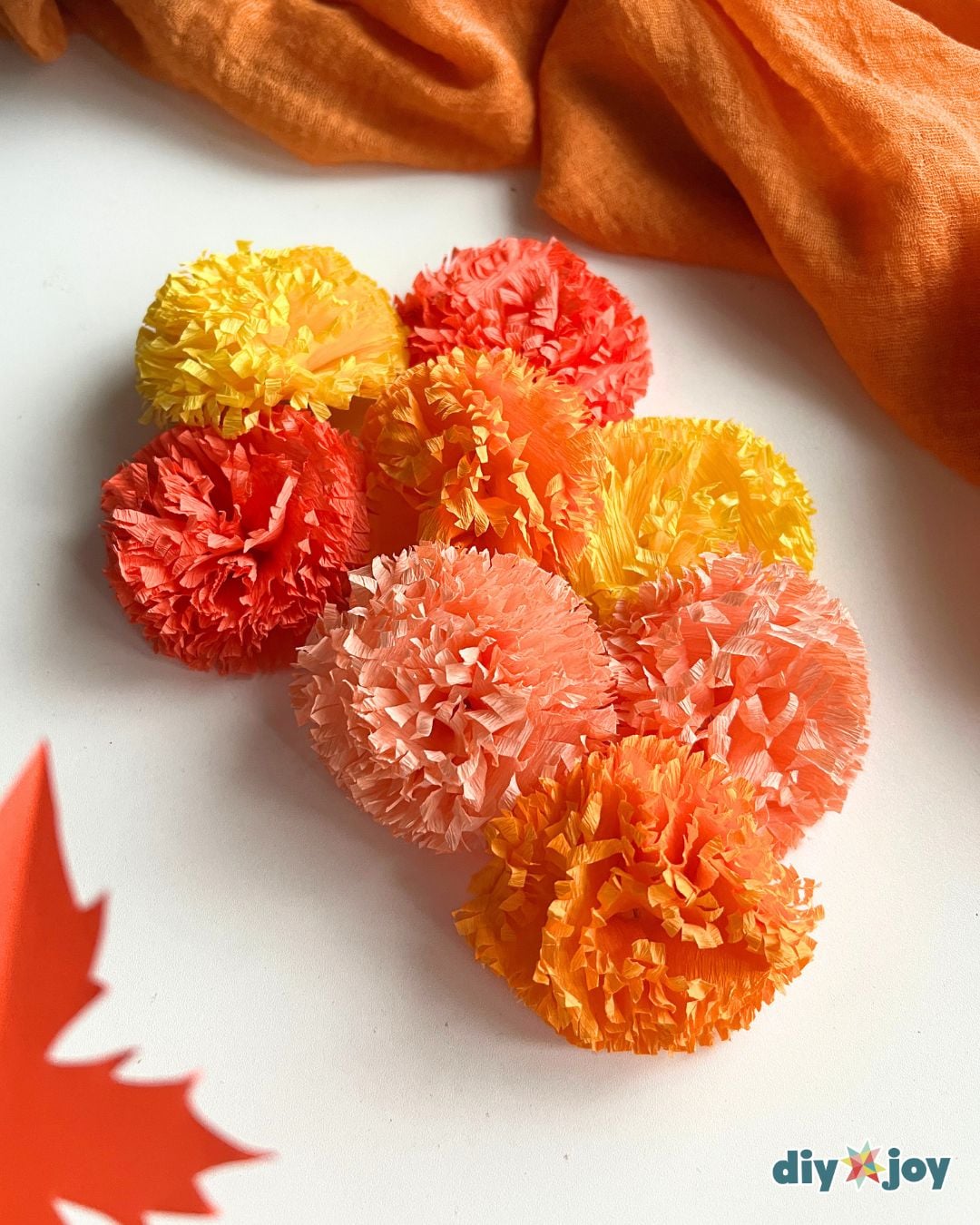 Cheap DIY Ideas - crepe paper marigold flowers styled with a paper fall leaf