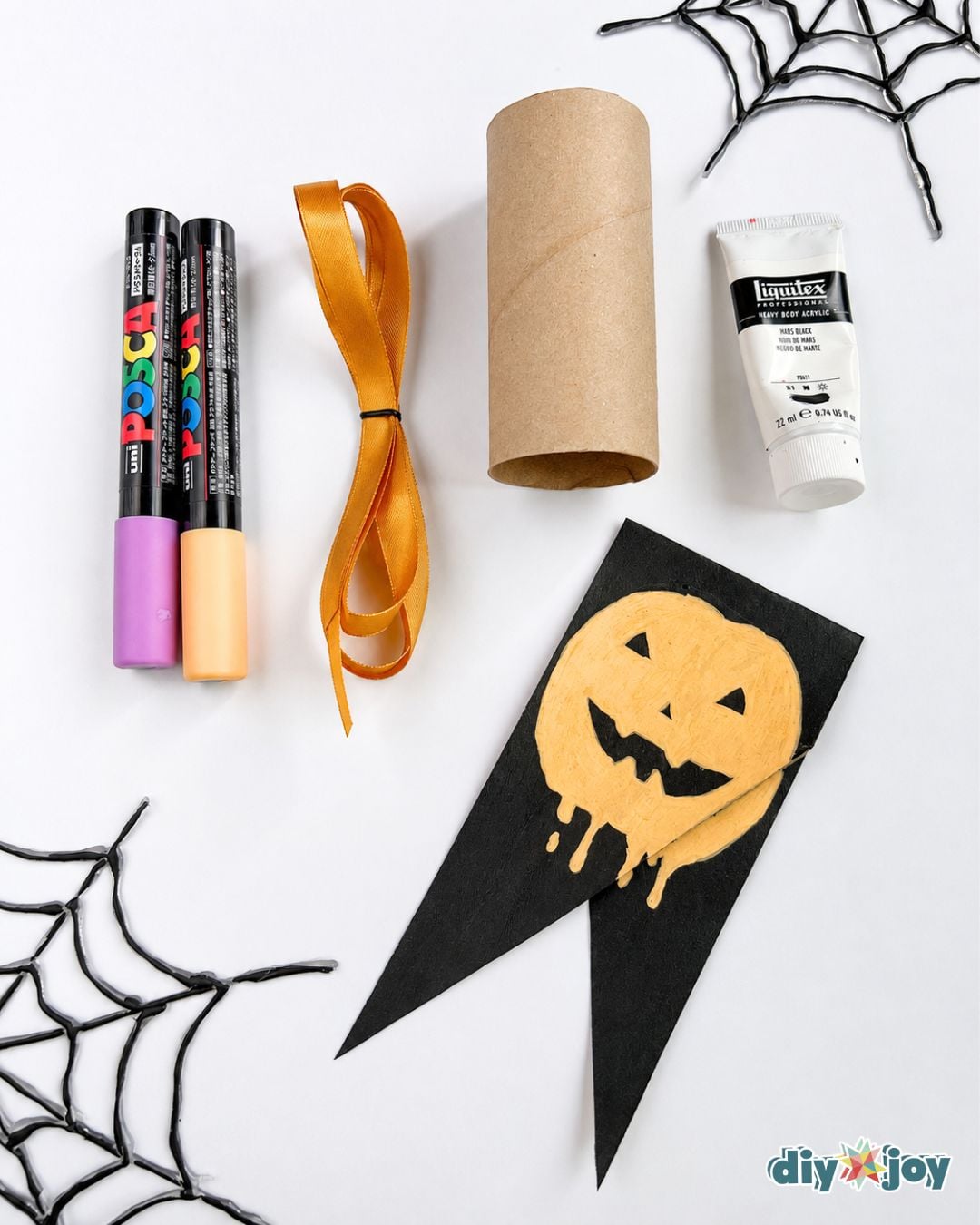 Easy Halloween crafts - the markers, paint, ribbon, and cardboard tube used to make a DIY Halloween banner