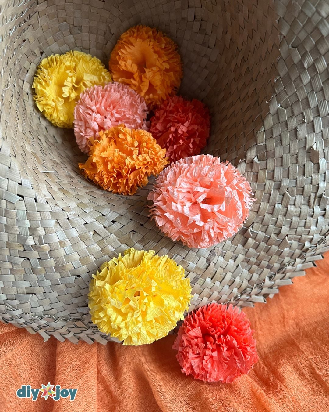 Best DIY Crafts - crepe paper marigold flowers displayed in a woven hat