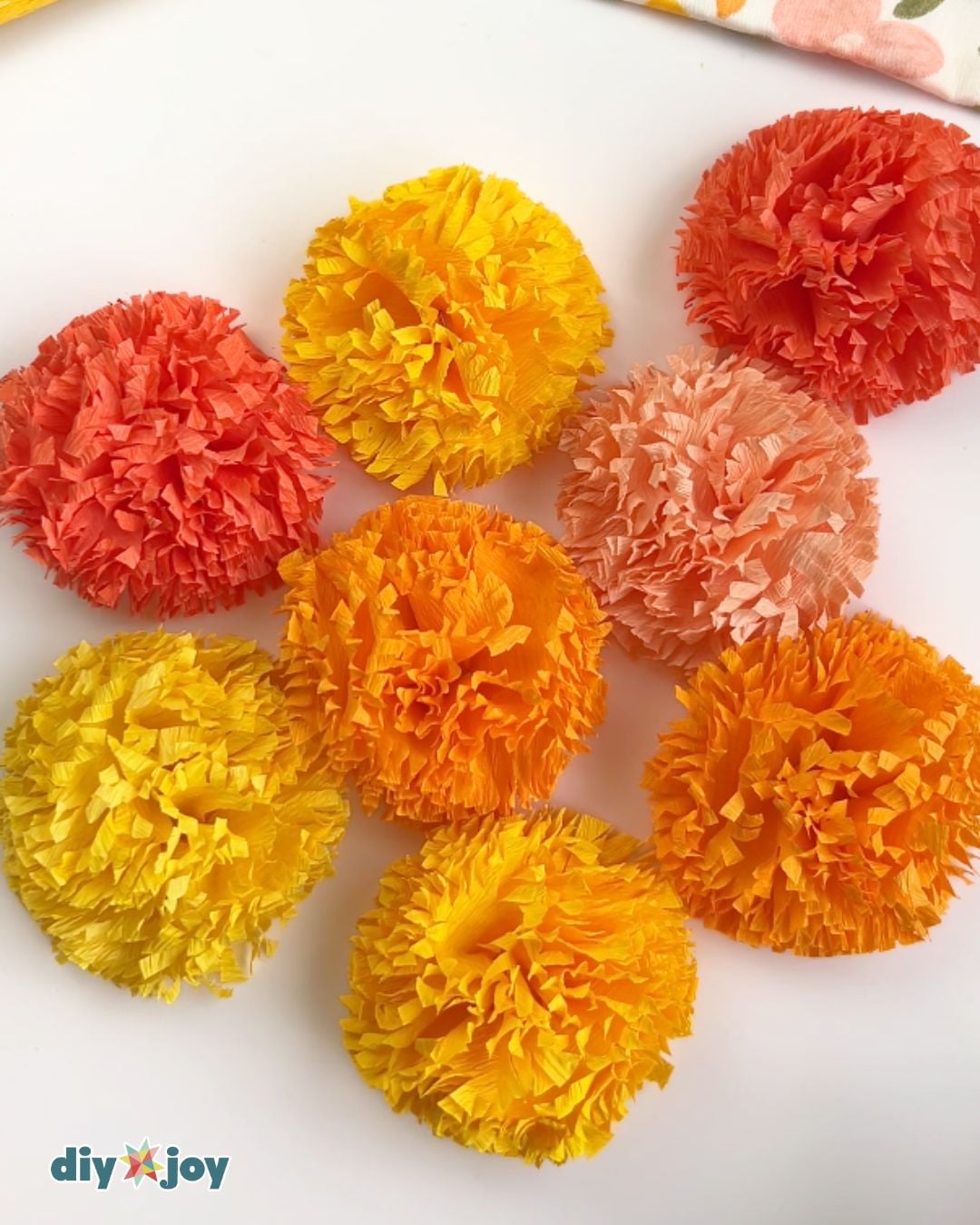 How to Make Paper Flowers - crepe paper marigolds arranged in a flower pattern