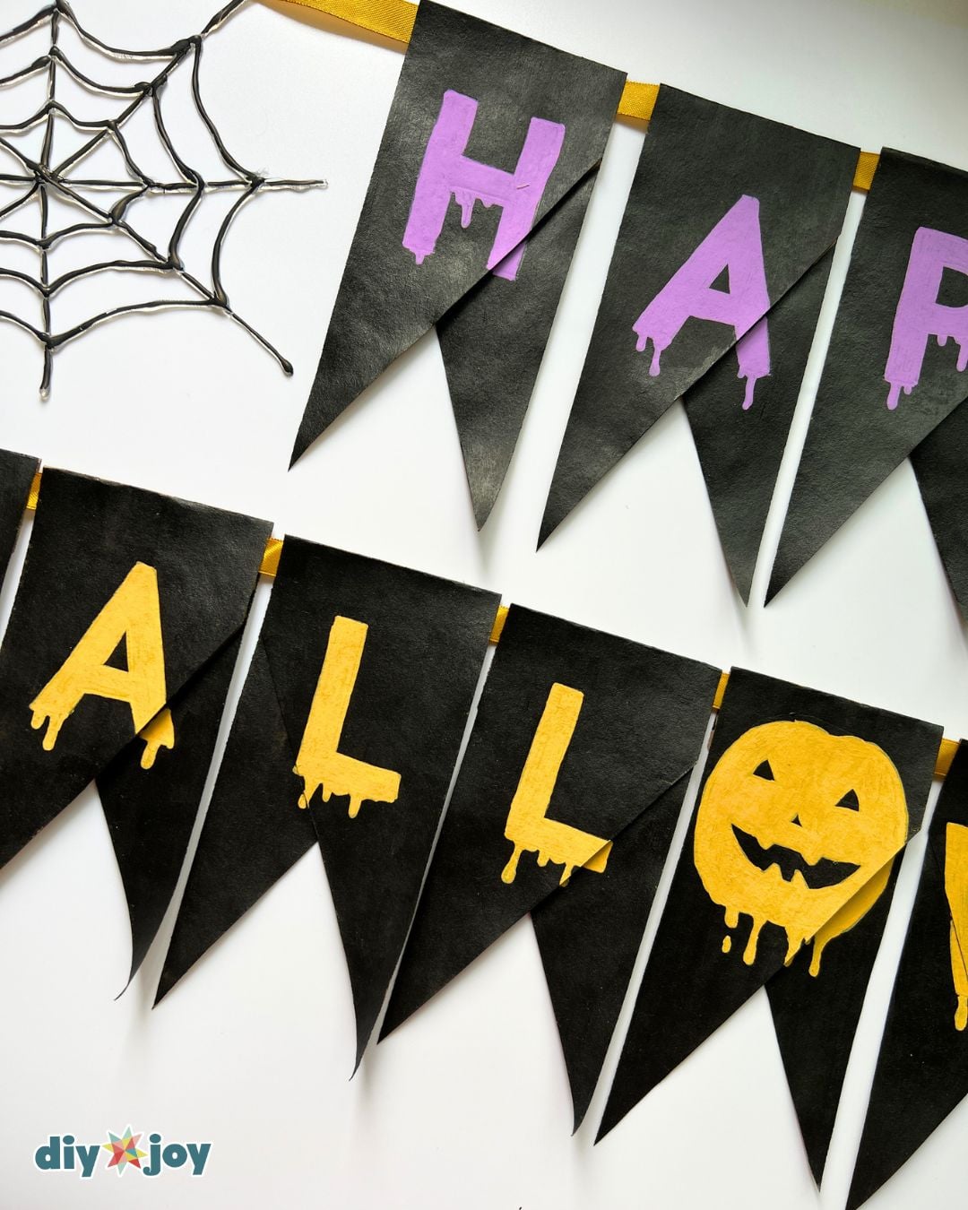 Halloween banner ideas - closeup of the drippy purple lettering on black toilet paper roll bunting