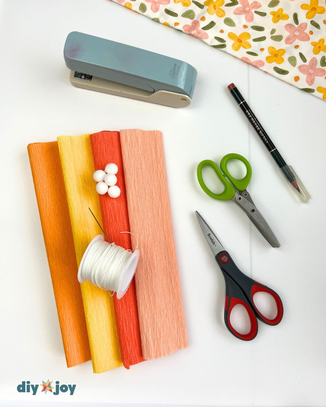 Craft Supplies Needed - crepe paper, scissors, thread, and pom-poms for marigold flowers