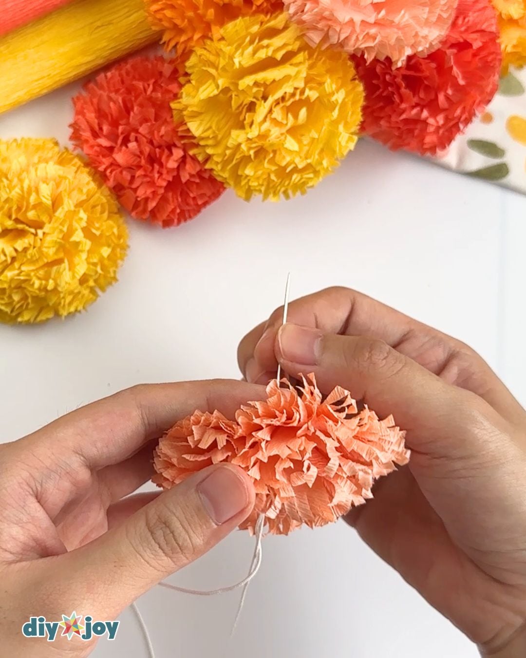 Fall Crafts - threading crepe paper marigold flowers onto string for a garland