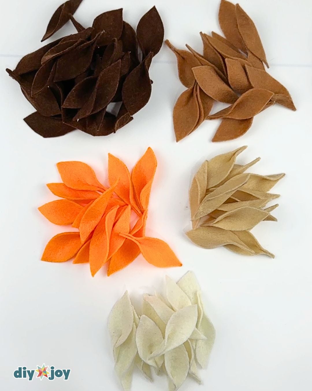 Fall decorations - sorted piles of cut felt leaves in brown, orange, cream, and tan for a diy fall wreath