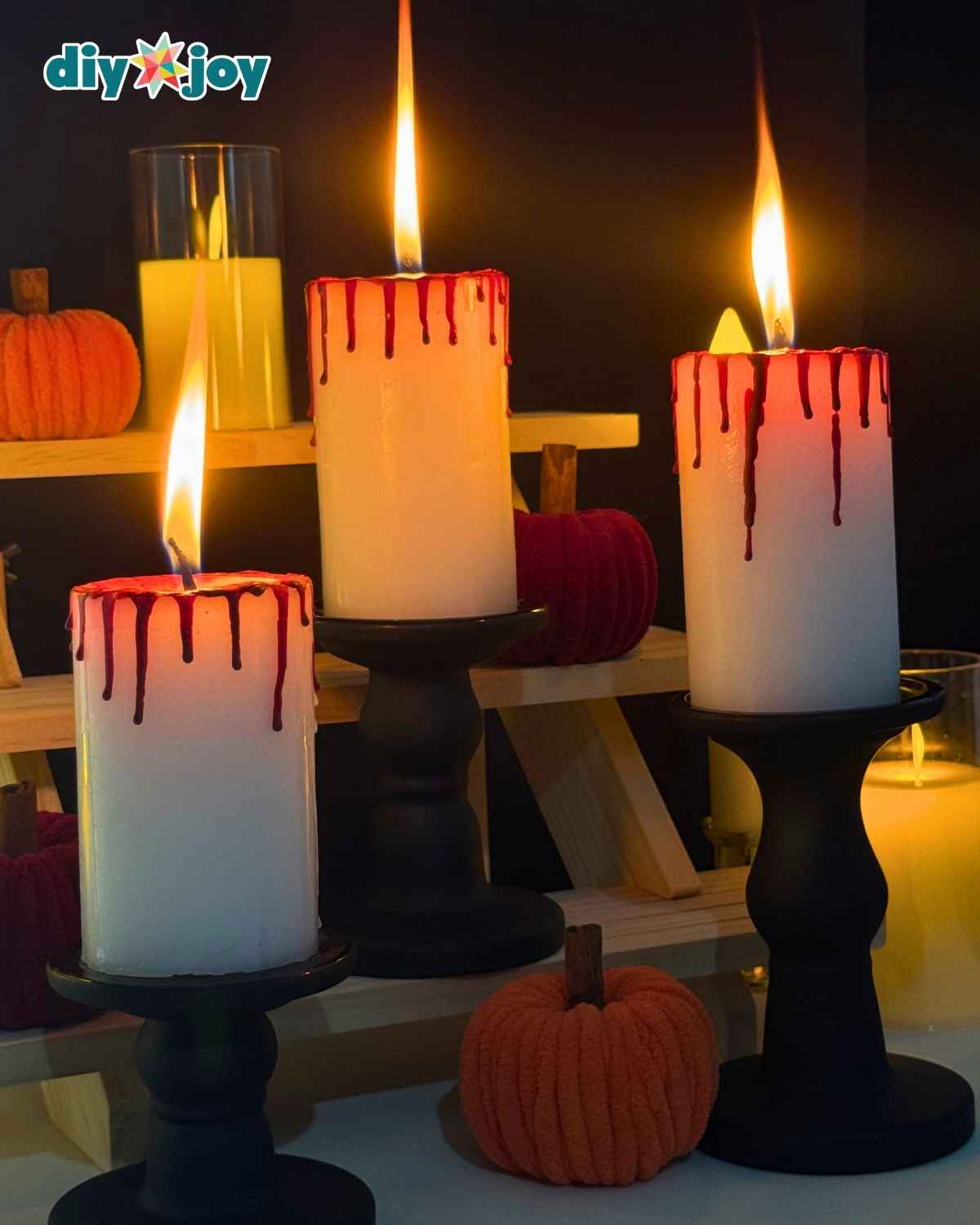Bloody candles arranged with other creepy Halloween decorations and dripping red wax
