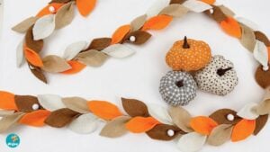 DIY fall leaf garland made from felt draped along a fireplace mantel