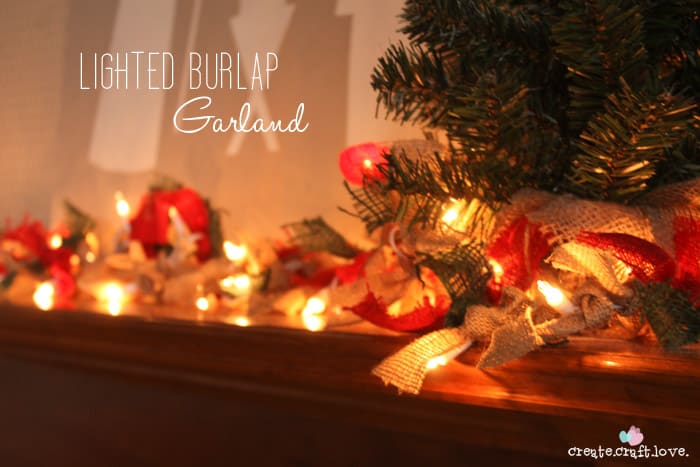 Lighted burlap garland with red and natural burlap strips draped on a mantel with glowing string lights