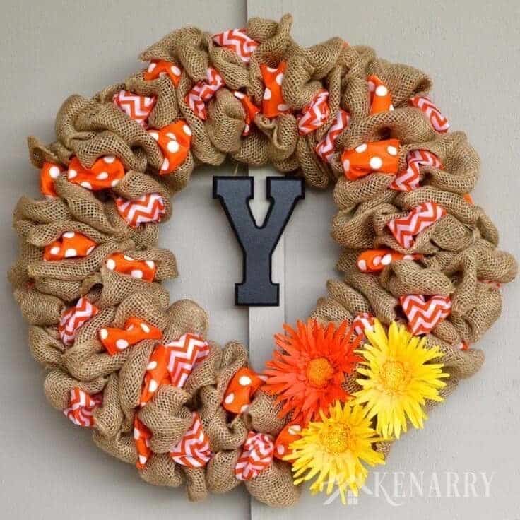 Burlap wreath with orange polka dot and chevron ribbon loops, a wood monogram letter and silk flowers