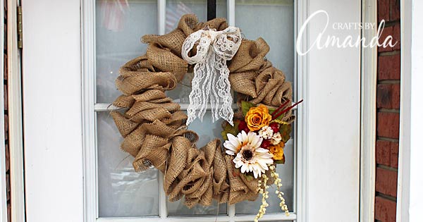 Classic burlap wreath made from a coat hanger with a lace bow and silk flowers hanging on a door