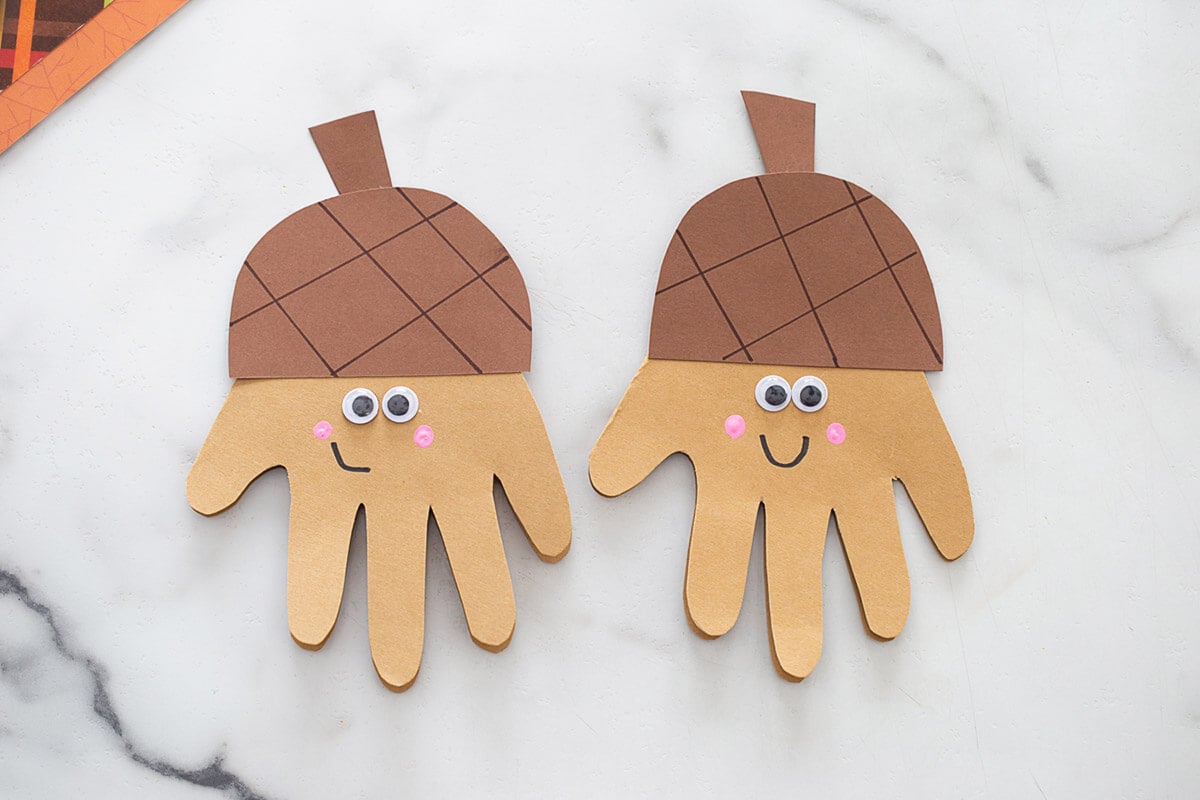 DIY handprint acorn craft made into a card with googly eyes, an easy fall activity and gift idea for kids