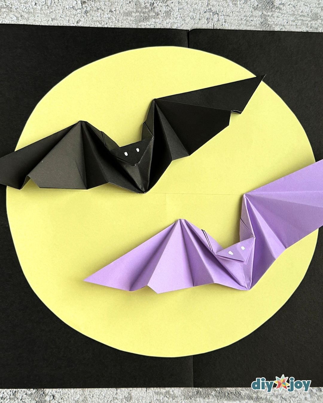 Halloween origami bat held in hand to show the flapping wings