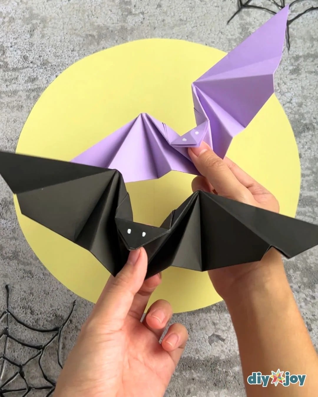 Halloween paper bats with flapping wings displayed on a table