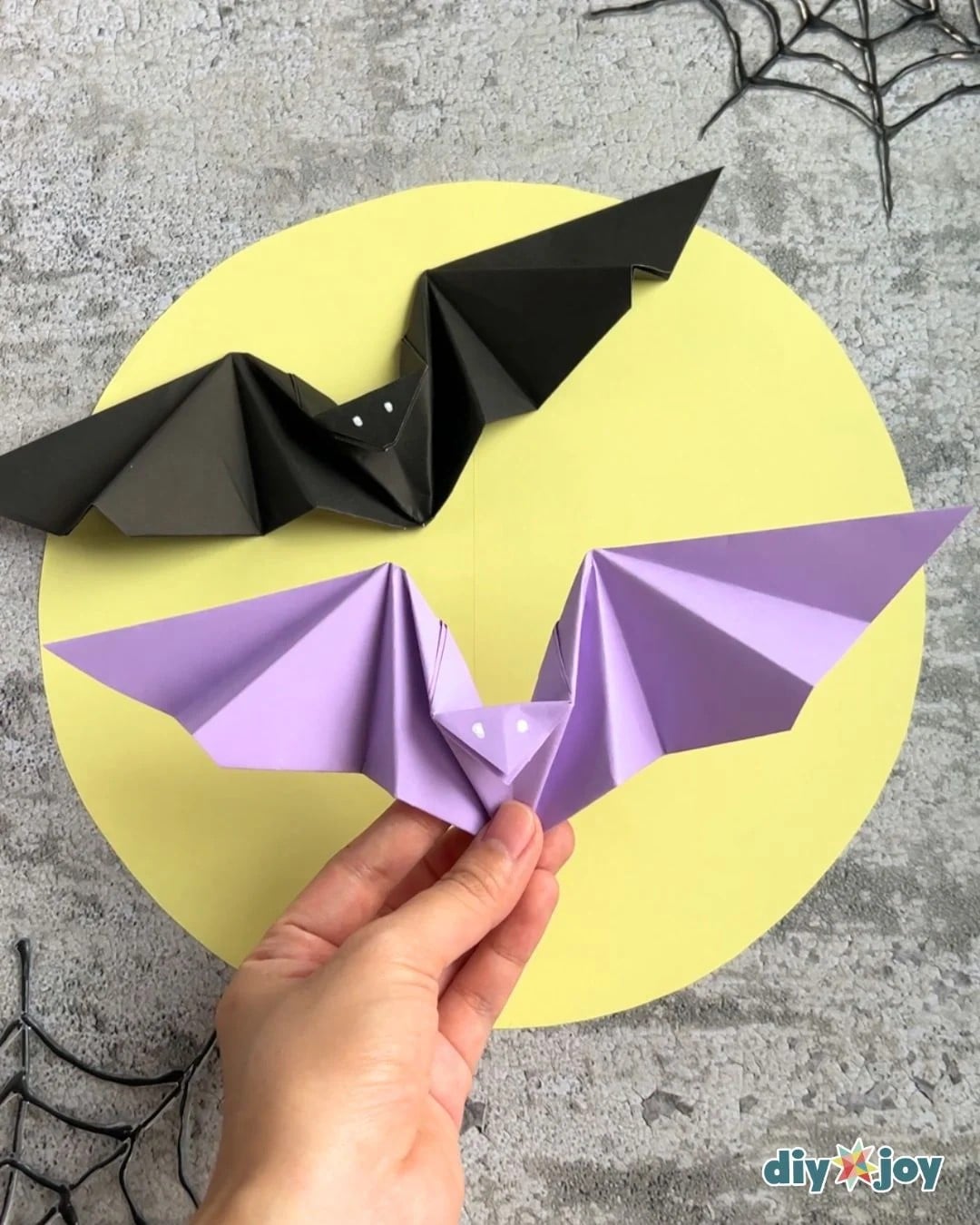 Easy Halloween paper bats made from folded origami paper with wings spread