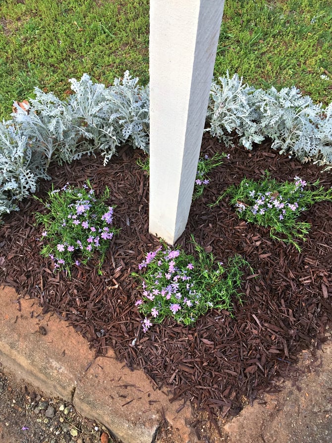 Reclaimed stone edging a flower bed around a mailbox post