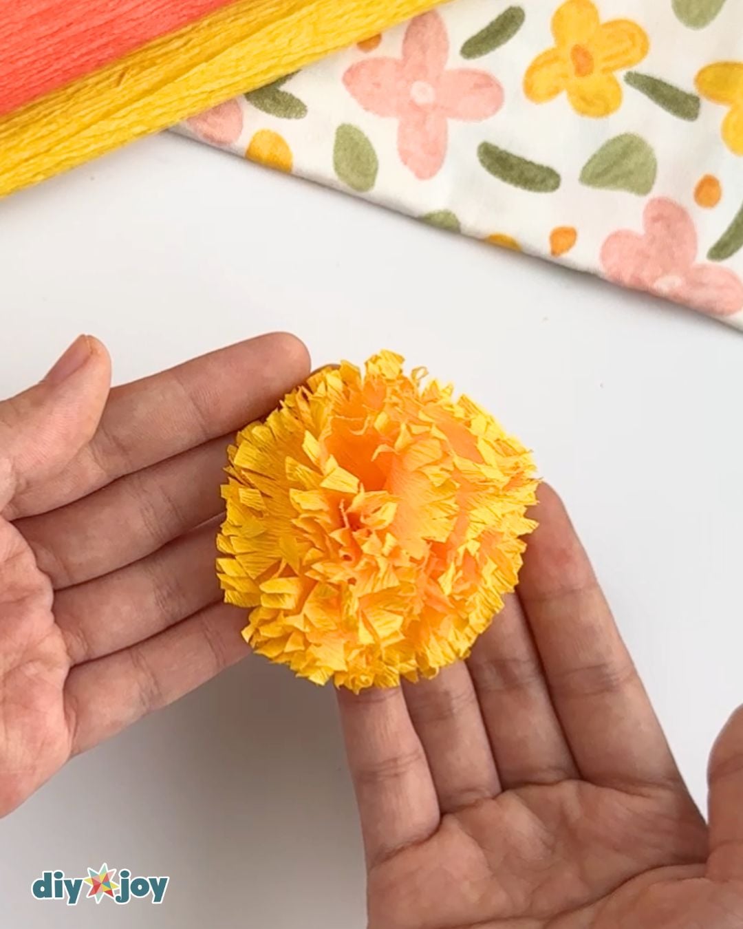 Crepe Paper Flowers - finished marigold bloom held in hand after scrunching