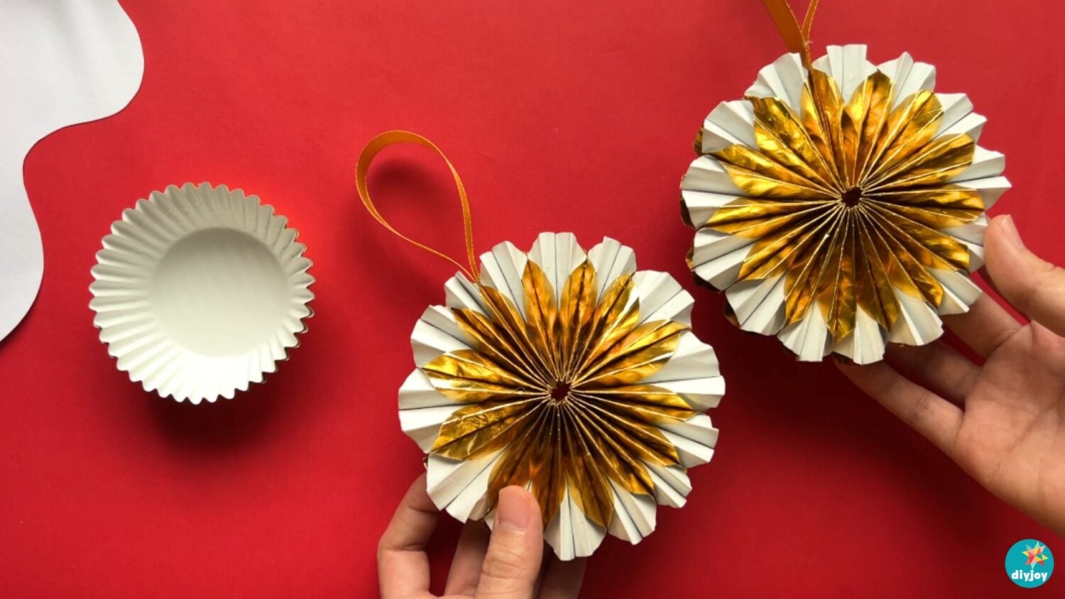 DIY Christmas ornaments made from gold metallic cupcake liners, shown finished with ribbon beside an unfolded liner