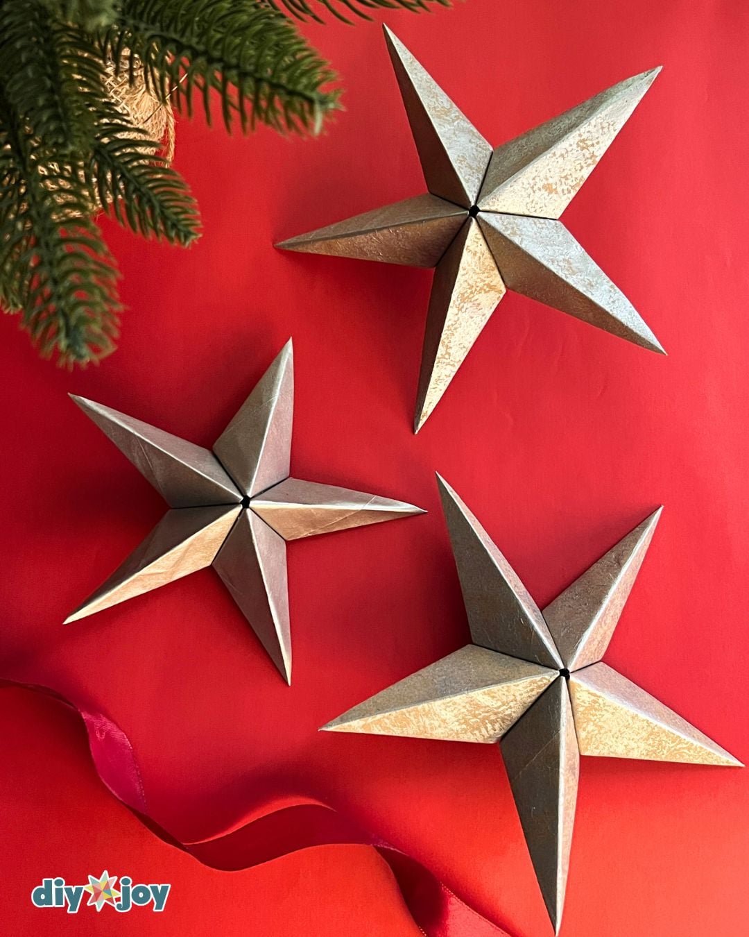 Handmade Christmas ornament - gold paper star tucked into pine branches with string lights, DIY decor