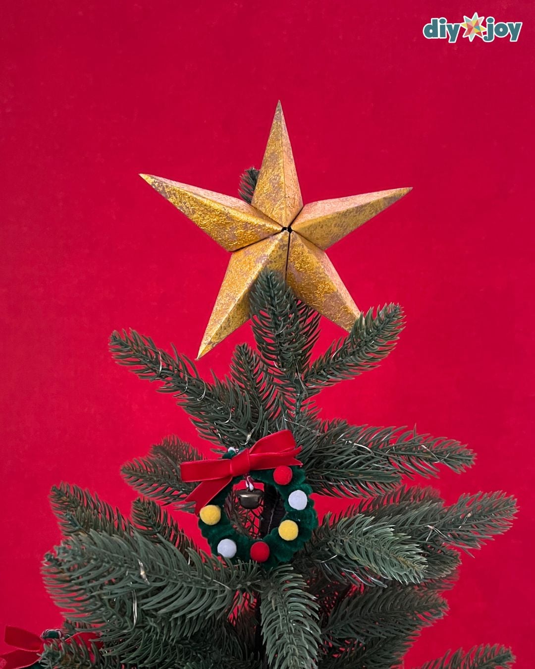 Paper bag star ornament used as a tree topper on a small tabletop Christmas tree display at home this season