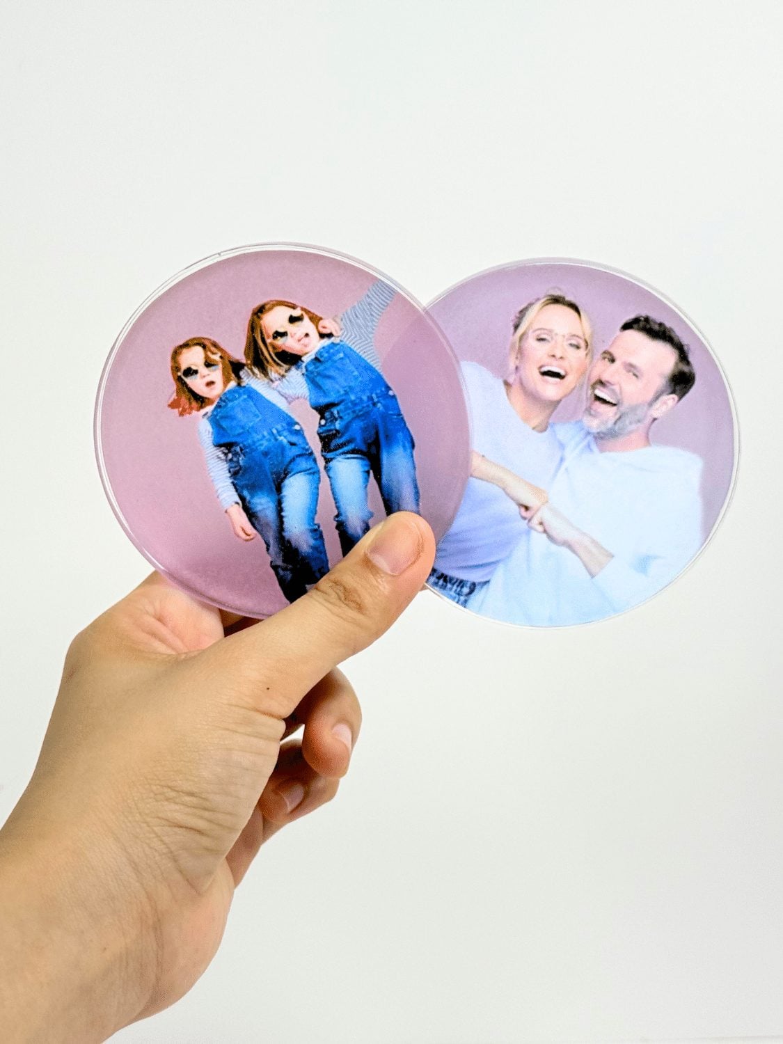 Round clear resin coaster with a photograph set inside it, resting on a pale table beside a coffee cup